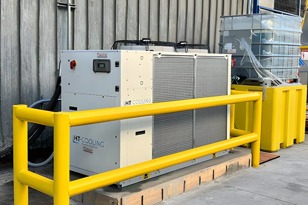 Equipo chiller HT Cooling instalado en planta, protegido con baranda amarilla