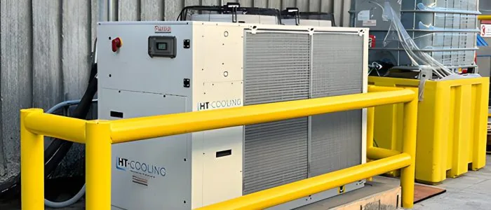 Equipo chiller HT Cooling instalado en planta, protegido con baranda amarilla