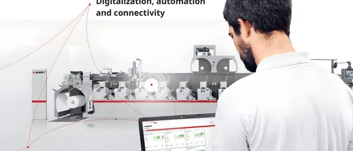 Operario monitoreando una línea de conversión Bobst digitalizada desde un notebook